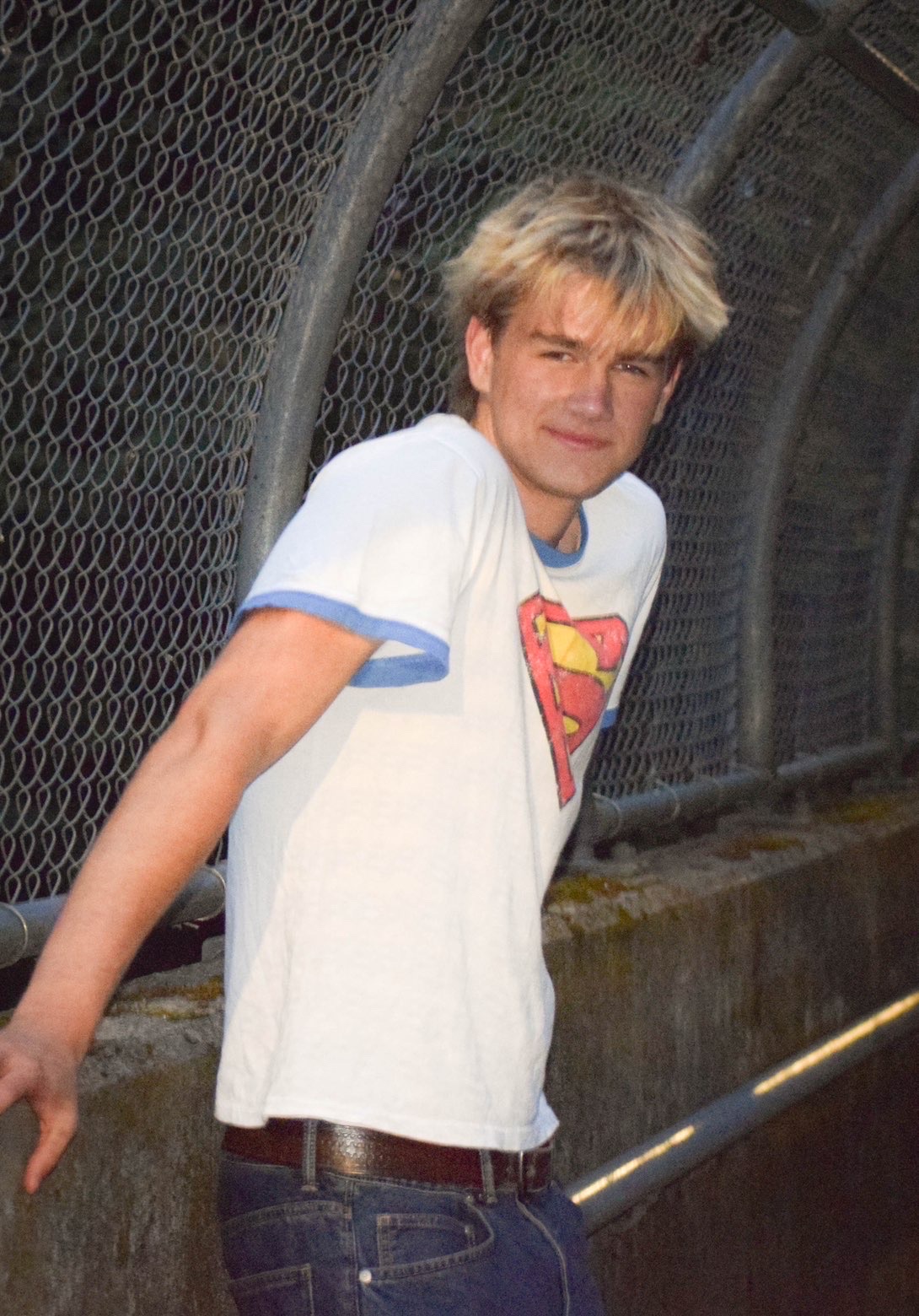 Finn Murray leaning on the railing of a fenced walkway